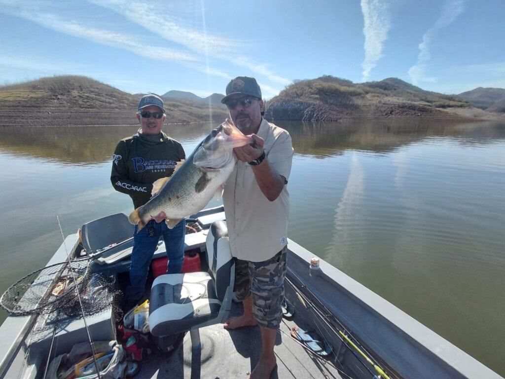 Fidel posando con una lobina trofeo de 7.18 lb en Presa Bacurato junto a su guía de pesca.